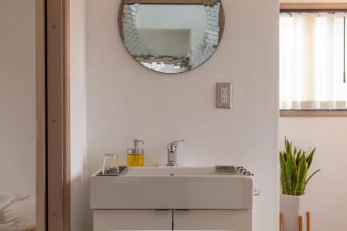 a bathroom with a sink and a mirror on the wall at Cachtte Nagisa - Vacation STAY 95387v in Zushi