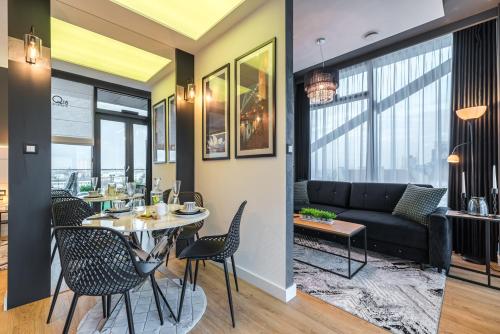 a living room with a table and chairs and a couch at Q18 ApartHotel in Bydgoszcz