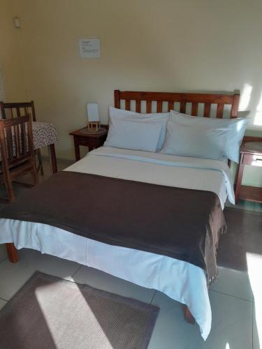 a bedroom with a large bed with white sheets and pillows at Eve's Accommodation in Windhoek