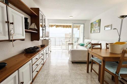 cocina con mesa y sala de estar en The Beach Apartment, en El Puig