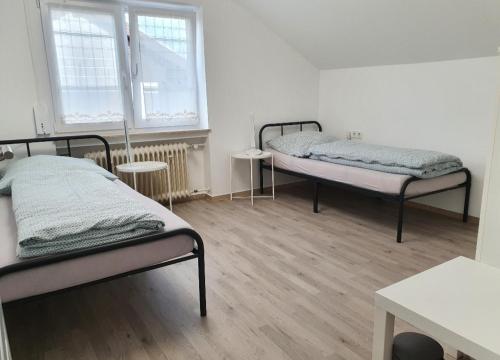 duas camas num quarto com duas janelas em Kaiser em Friedrichshafen