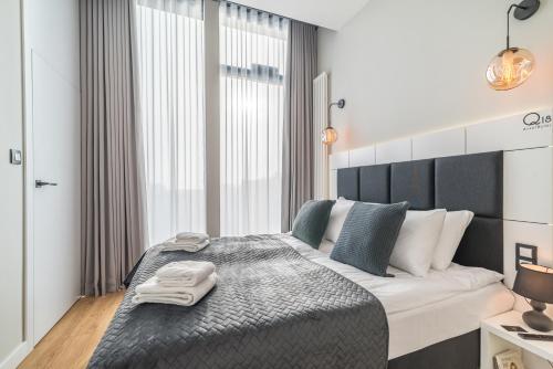 a bedroom with a large bed with two towels on it at Q18 ApartHotel in Bydgoszcz