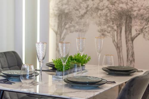 a dining room table with glasses and plates on it at Q18 ApartHotel in Bydgoszcz
