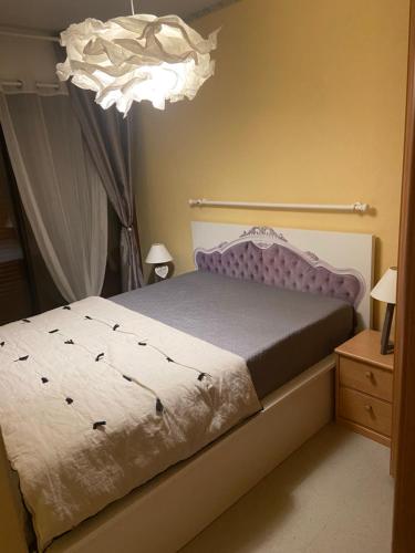 una camera con letto e lampadario a braccio di Appartement cocooning a Villard-de-Lans