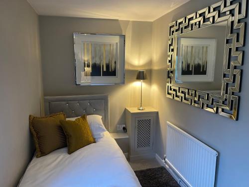 a bedroom with a bed and two mirrors on the wall at Cosy Cottage - Church St, Bawtry - Entire Cottage in Bawtry