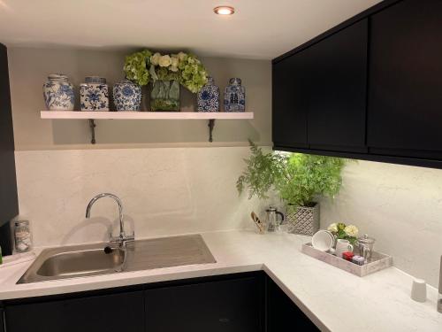 uma cozinha com um lavatório e vasos azuis e brancos em 'Cosy Cottage' - 2 Bed - Central Bawtry - Entire Cottage em Bawtry