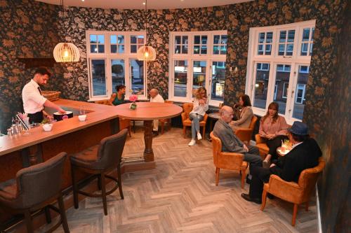 a group of people sitting around a bar in a restaurant at Gästehaus Seewarte in Flensburg