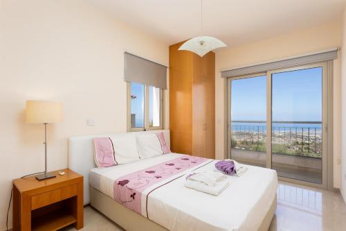 a bedroom with a bed with a view of the ocean at Villa Panorama Tessera in Droushia