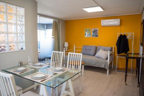 ein Wohnzimmer mit einem Tisch, Stühlen und einem Sofa in der Unterkunft 3C’s Athens South @Delta: SNFCC / Faliro Seaview Penthouse in Athen