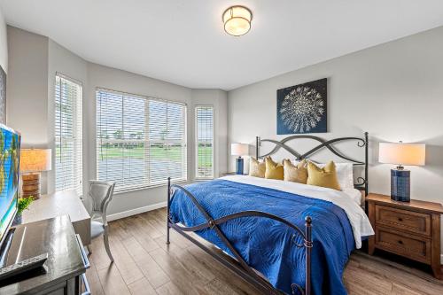 a bedroom with a bed and a desk and windows at Solterra Golf Condo at the Lely Resort in Naples