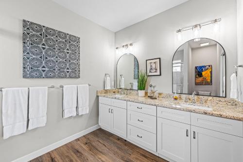 a white bathroom with two sinks and two mirrors at Solterra Golf Condo at the Lely Resort in Naples