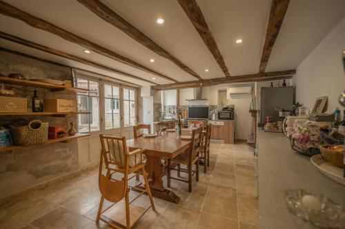 une cuisine et une salle à manger avec une table et des chaises dans l'établissement Le Balesté - Logement 1, à Montesquieu