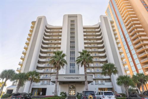 aominium building with palm trees in front of it at Three-Bedroom Apartment in Orange Beach
