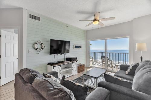 a living room with a couch and a flat screen tv at Three-Bedroom Apartment in Orange Beach