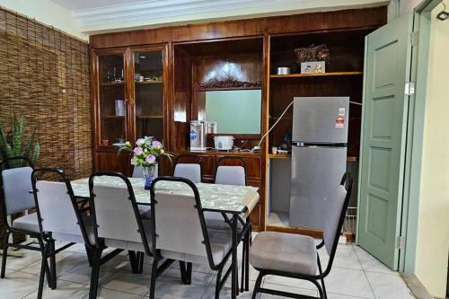 a dining room with a table and chairs and a refrigerator at Kenyalang Piasau Homestay in Miri