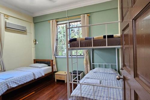 two bunk beds in a room with a window at Kenyalang Piasau Homestay in Miri
