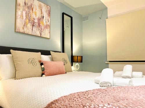 1 dormitorio con 1 cama blanca grande con almohadas rosas en Luxury Flat at Temple Bar Dublin, en Dublín