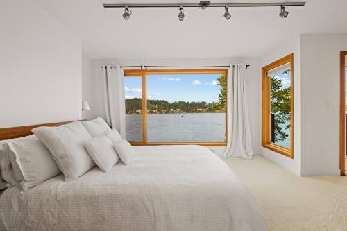 シドニーにあるSeaside Sanctuaryの白いベッドルーム(大型ベッド1台、大きな窓付)