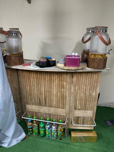 a wooden stand with two jars and soda bottles on it at L'Endémik Kréol in Saint-André