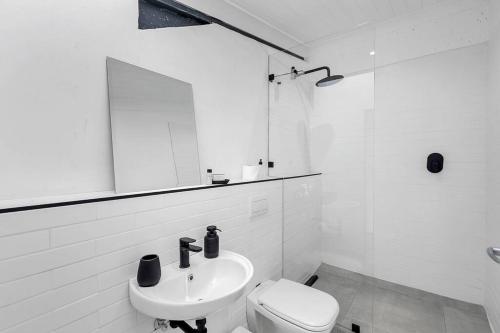 a white bathroom with a sink and a toilet at Spice Yard Lofts on Voortrekker-B116 in Cape Town