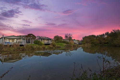 a view of a lake with houses and a sunset at Nestledstays- Primrose in Arundel