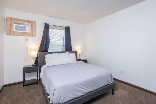 ein Schlafzimmer mit einem weißen Bett und einem Fenster in der Unterkunft Private/Quiet 2-Bed Apartment in Dayton