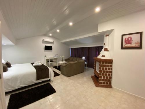 um quarto com uma cama e uma sala de estar em The Rock Guest House em Ponta Delgada