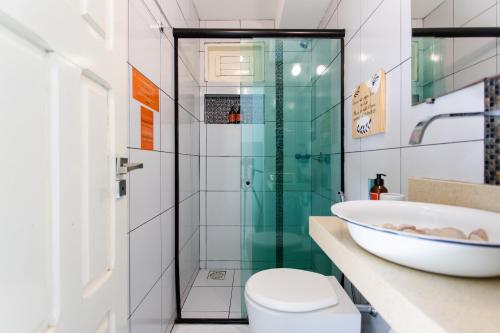 a bathroom with a glass shower and a sink at Vila Charme in Jericoacoara