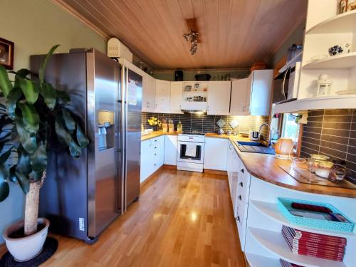 a kitchen with white cabinets and a stainless steel refrigerator at Mikael's Bed & Spa in Sandefjord