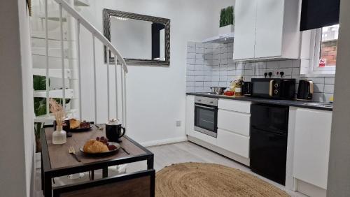 a kitchen with white cabinets and a table in it at Studio City Getaway Apartment in Birmingham
