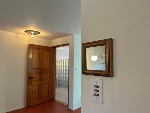 a hallway with a door and a mirror on a wall at Berliner House in Busan