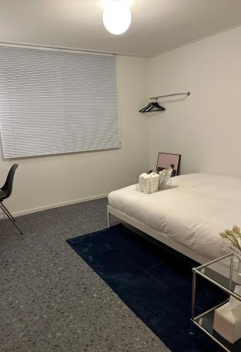 a bedroom with a bed and a chair and a window at Berliner House in Busan