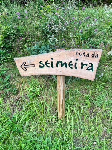 a wooden sign in the grass with writing on it at Aldea Rural y Gastro Restaurante Casona de Labrada in Labrada