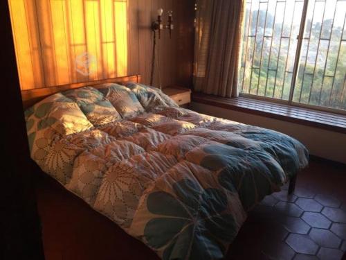 un letto in una camera da letto con finestra di Cabaña frente al mar a El Quisco