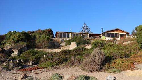 una casa sulla cima di una spiaggia sabbiosa di Cabaña frente al mar a El Quisco