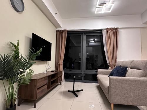 a living room with a couch and a tv at New 2BR or 3BR Cozy Urban Suite Homestay at Georgetown8-10pax by URBAN STAYCATIONS LOD in Jelutong