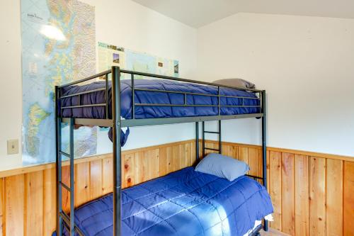 a bunk bed in a room with a blue bed at Forested Coffman Cove Cabin with Wood-Burning Stove! in Coffman Cove
