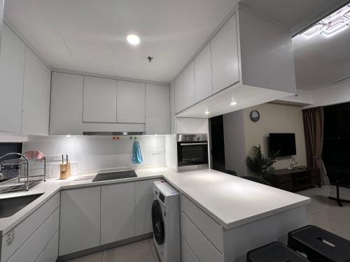 a white kitchen with white cabinets and a dishwasher at New 2BR or 3BR Cozy Urban Suite Homestay at Georgetown8-10pax by URBAN STAYCATIONS LOD in Jelutong