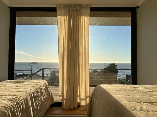 1 dormitorio con vistas al océano desde una ventana en Cabañas Pacífico Matanzas Completa en Matanzas