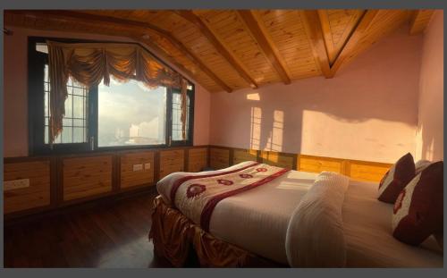 a bedroom with a bed and a large window at Wintry homes 5 Bhk Villa in Shimla