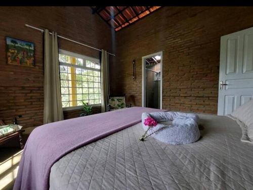 a bedroom with a large bed with a flower on it at Chalés Guaíras in Mulungu