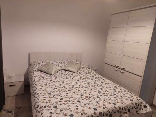 a bedroom with a bed and a dresser at Fresh Apartman in Târgu-Mureş