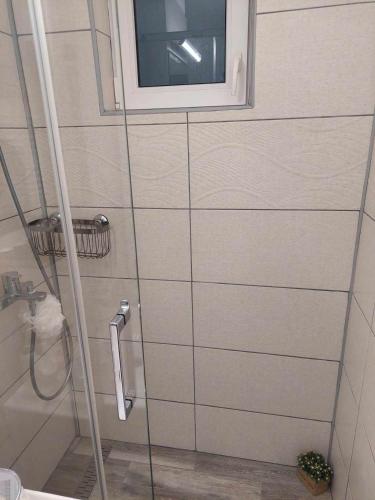 a bathroom with a shower with a window at Fresh Apartman in Târgu-Mureş
