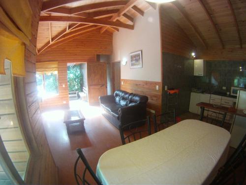 a living room with a bed and a couch at Cabañas Santa Maria Pucon in Pucón