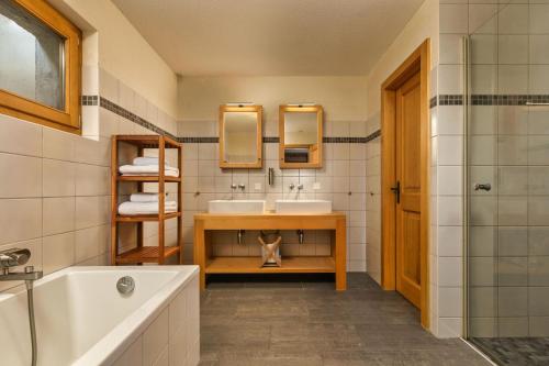 a bathroom with a tub and a sink at Chalet Elbaz - Swiss Chalet with breathtaking views in La Tzoumaz
