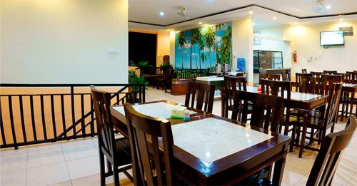 a dining room with tables and chairs in a restaurant at Belitong Inn in Tanjungpandan