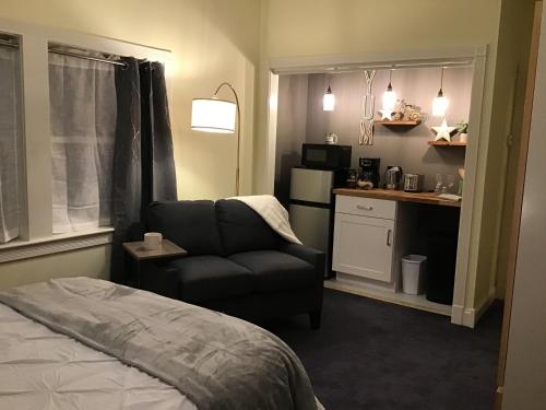 Il comprend une chambre avec un lit et une chaise ainsi qu'une cuisine. dans l'établissement Star Suite on the Midcoast, à Rockport