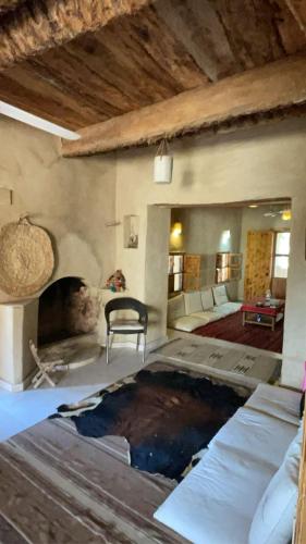 Siwa desert home في سيوة: غرفة معيشة مع موقد وأريكة