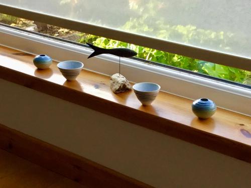 a row of bowls sitting on a window sill at Shamerbrea Design Townhouse in Inverness