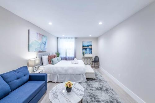 a living room with a blue couch and a bed at 20 Guest Oasis - Spacious SF Skyline Getaway! in San Francisco